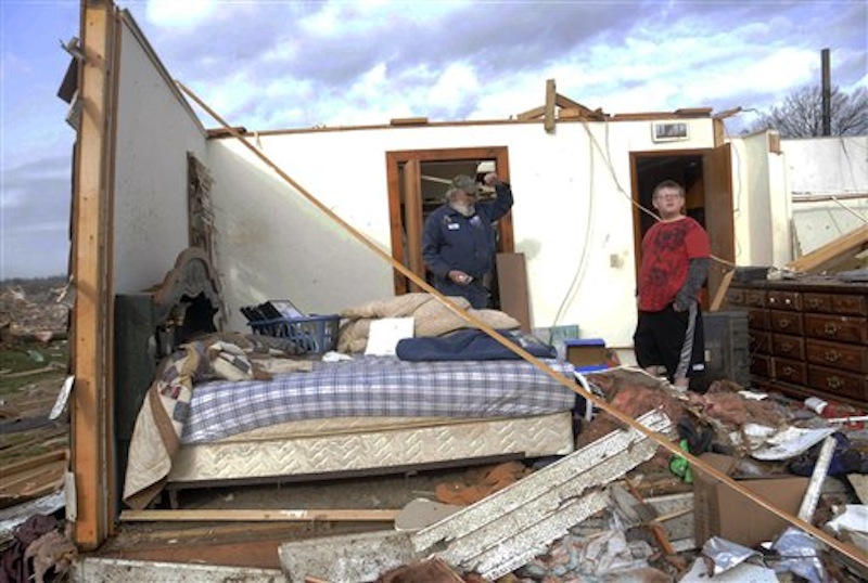 Keith Hucke, left, and Devyn Byrd, 14, survey the damage to Hucke's house after a severe storm hit in the early morning hours on Wednesday, Feb. 29, 2012, in Harrisrbug, Ill. Hucke said he was in his bed when the wall right next to him collapsed during the storm. A severe pre-dawn storm pounded portions of southern Illinois on Wednesday. Nine deaths have been reported in Harrisburg and left the city's medical center scrambling to treat an influx of injured, the hospital's top administrator said. (AP Photo/The Southern Illinoisan)