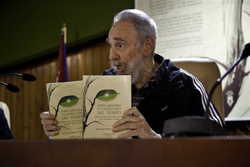 In this Feb. 3, 2012 photo released by the state media website Cubadebate, Cuba's leader Fidel Castro holds two copies of his book 'Guerrillero del Tiempo,' or 'Time Warrior' during its presentation in Havana, Cuba. (AP Photo/Cubadebate, Roberto Chile)