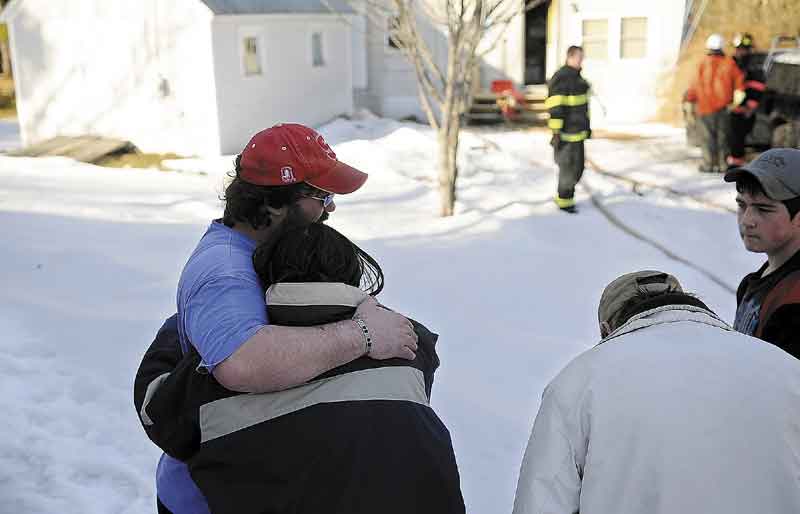 NO INJURIES: Kevin Sansouci comforts his wife, Tracey, after a fire damaged their mobile home Wednesday in Gardiner. Smoke damaged the interior but no injuries were reported. At right are their friend Richard Trask Jr. and his father, Richard Trask Sr.
