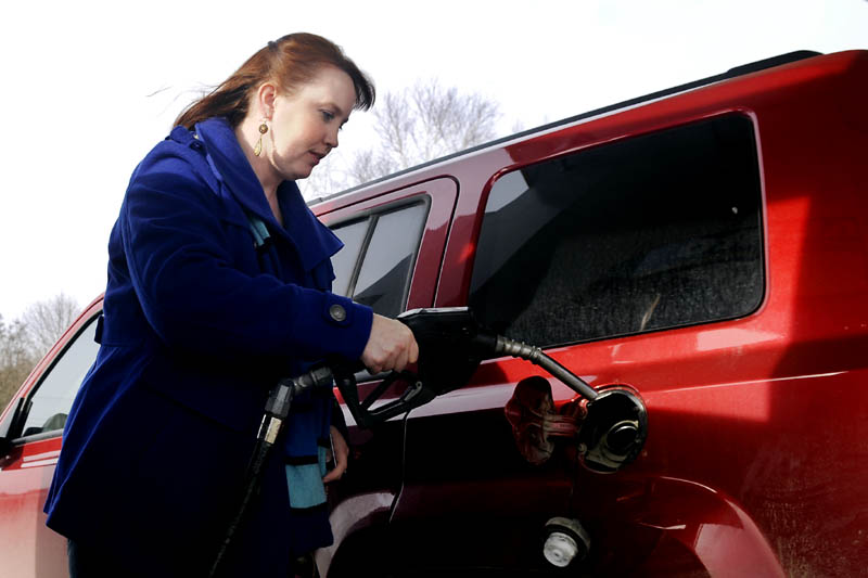 Carrie Parker, of Belgrade, fills up her vehicle Tuesday in Augusta. Gas prices are spiking across the country.