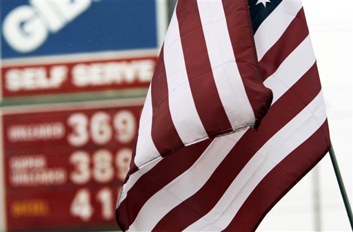 An American flag flaps in front of gas prices posted at a gas station in Topsham today. A price-monitoring website is warning Maine motorists that gasoline prices could rise sharply during the next few days.