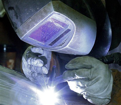 A workman welds a stainless steel tank at JV Northwest, in Camby, Ore., on Monday. Busier factories are helping drive the economy.