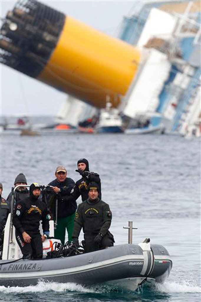 In this Jan. 27 photo, Italian Financial police scuba divers sail around the grounded cruise ship Costa Concordia off the Tuscan island of Giglio, Italy. (AP Photo/Pier Paolo Cito)