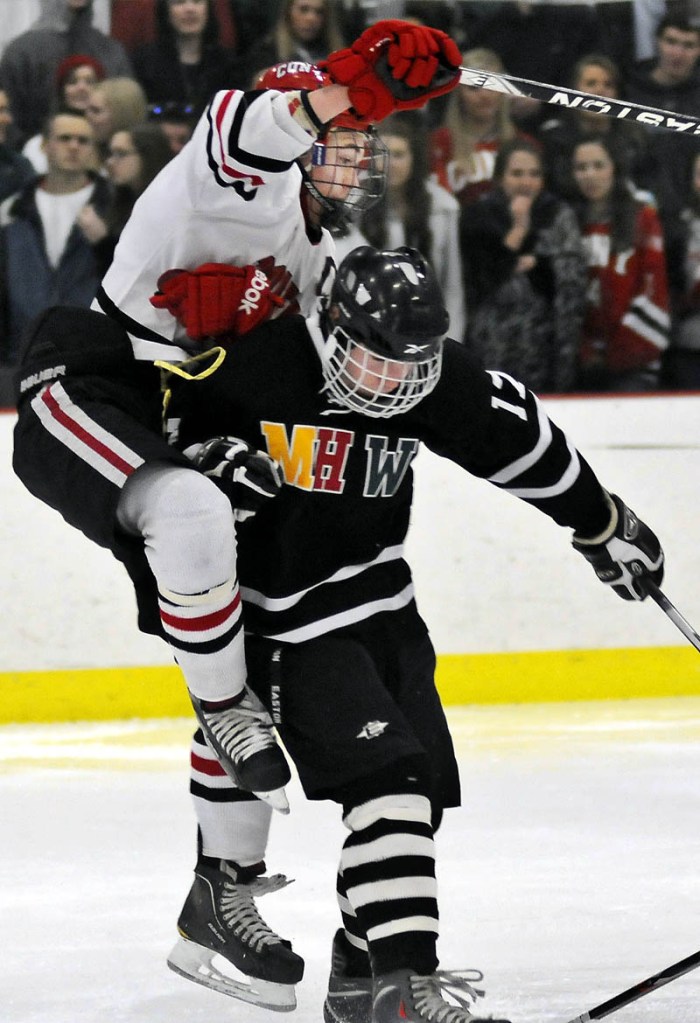 FACE OFF: Cony High School's Blane Galen Casey, left, bounces off of MHW's Zach Glazier during a hockey match up Tuesday in Readfield.