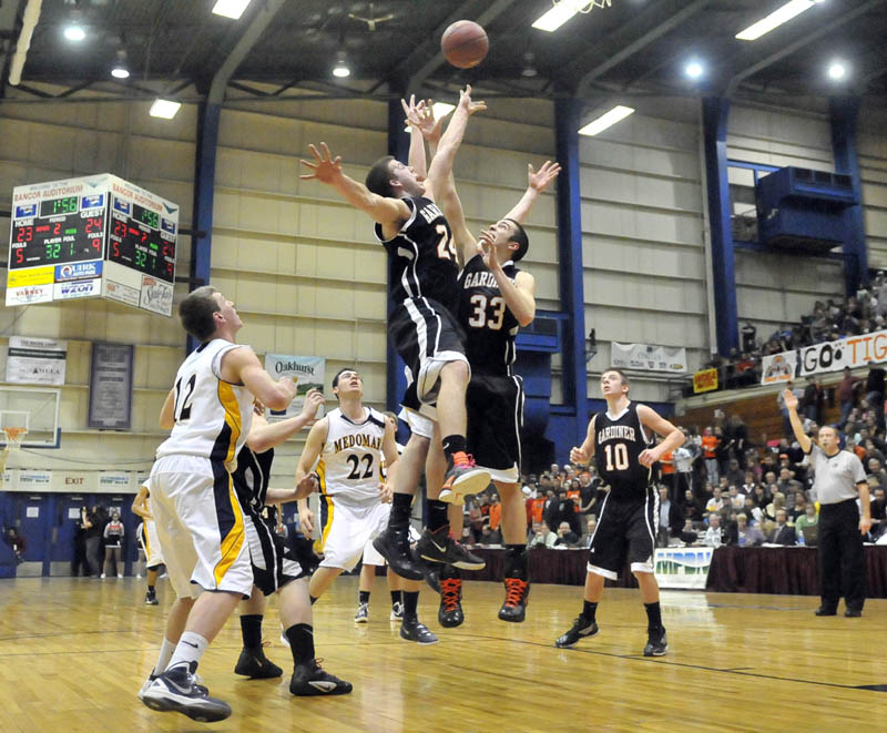 Photo by Michael G. Seamans Gardiner High School's Matt Hall, 24, and Aaron Toman, 33, jump for the rebound in the first half of the Eastern Class B semi-finals at the Bangor Auditorium Wednesday. Gardiner defeated Medomak Valley 57-46.