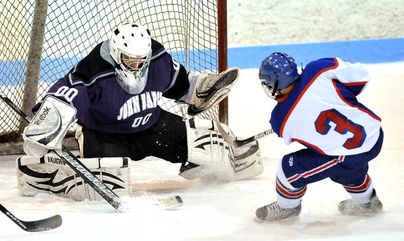 Messalonskee High School's Joshua Towle, 3, scores on John Bapst Memorial High School goalie Jaron Leonard, 00, in the first period in an Eastern B regional quarterfinal game at Sukee Arena in Winslow Tuesday night.