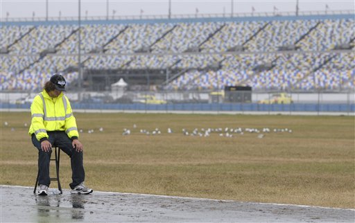 Parking attendant Tyler Bounelis, of Ormond Beach, Fla., sits near an empty parking lot at Daytona International Speedway in Daytona Beach, Fla., today.