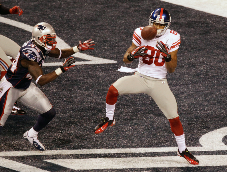New York Giants wide receiver Victor Cruz makes a catch for a touchdown as New England Patriots safety James Ihedigbo defends during the first quarter of Super Bowl XLVI in Indianapolis.