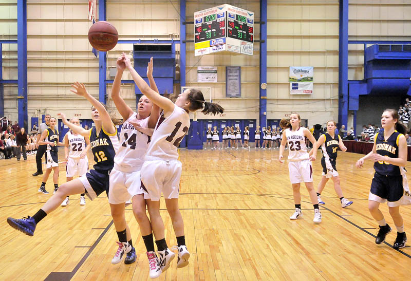 Photo by Michael G. Seamans Nokomis High School's Marissa Shaw, 14, center left, and teammate Kylie Richards, 12, center right, battle for the ball with Medomak Valley High School's Mallory Robbins, 12, in the second half of the Eastern Class B quarterfinals game at the Bangor Auditorium Saturday. Nokomis defeated Medomak Valley 58-51.