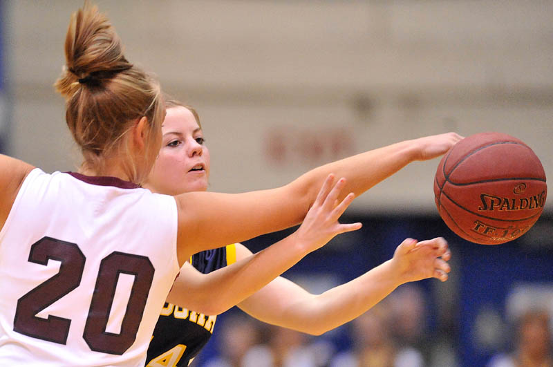 Photo by Michael G. Seamans Nokomis High School's Emilee Reynolds, 20, gets a hand on the ball as Medomak Valley High School's Taylor Simmons, 14, tries to pass in the second half of the Eastern Class B quarterfinals game at the Bangor Auditorium Saturday. Nokomis defeated Medomak Valley 58-51.