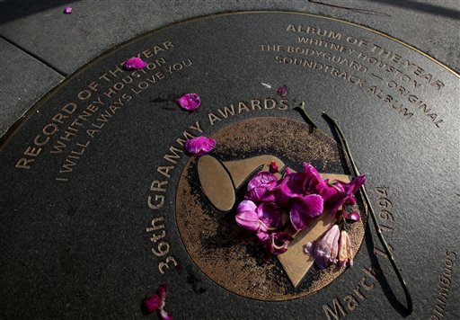 Flowers are placed on a sidewalk plaque honoring Whitney Houston's Grammy wins in 36th Grammy Awards, outside the Grammy Museum in Los Angeles.