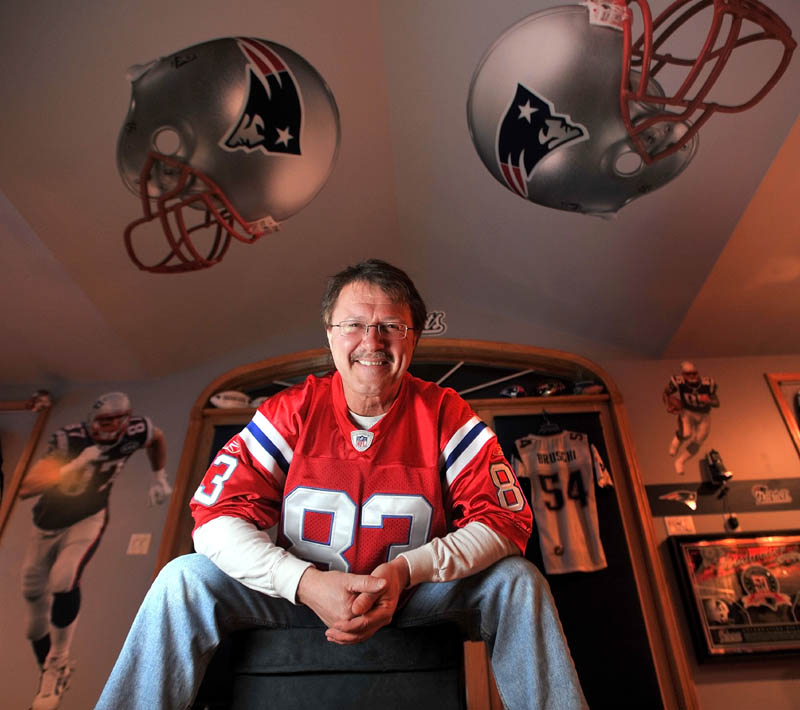 PRIDE AND JOY: New England Patriots super-fan, Tony Yotides, poses for a portrait in his Patriots lair above the garage of his Belgrade Lakes home on Thursday. Yotides expects to have about 50 people over Sunday to watch the game.