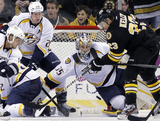Boston Bruins' Chris Kelly (23) tries to get a shot off in front of Nashville Predators' goalie Pekka Rinne (35) as the Predators' Ryan Suter (20) defends in the third period Saturday in Boston. The Bruins won 4-3 in a shootout.