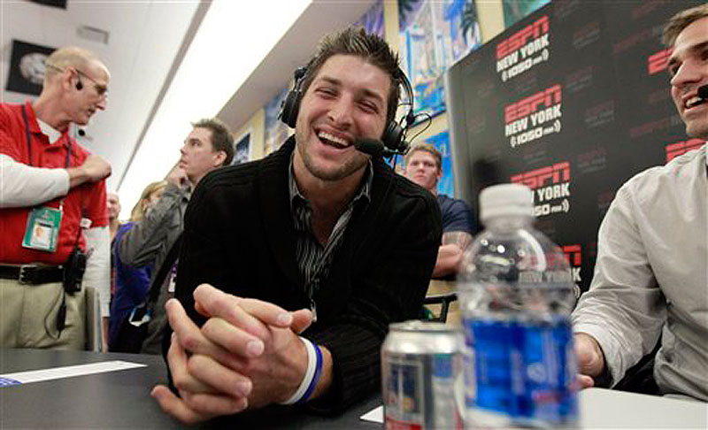 Denver Broncos quarterback Tim Tebow, left, laughs during an interview on radio row at the Super Bowl XLVI media center on Thursday in Indianapolis. (AP Photo/David J. Phillip)