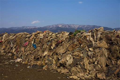 This Feb. 21, 2012, photo shows clothing lying in heaps at the site of a neighborhood destroyed by the 2011 earthquake and tsunami, in Rikuzentakata, Japan. Scientists believe 1 million to 2 million tons of lumber and other construction material, fishing boats and other fragments of coastal towns are still in the water and are being carried across the Pacific by ocean currents.