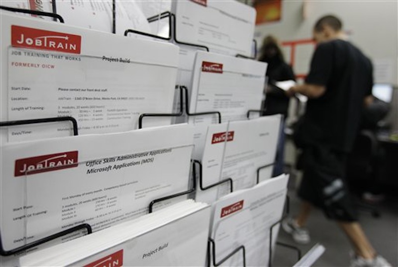 This Feb. 14 photo shows job postings at JobTrain employment center in Menlo Park, Calif. The number of people seeking unemployment benefits fell to the lowest point in almost four years last week, the latest signal that the job market is steadily improving. (AP Photo/Paul Sakuma)