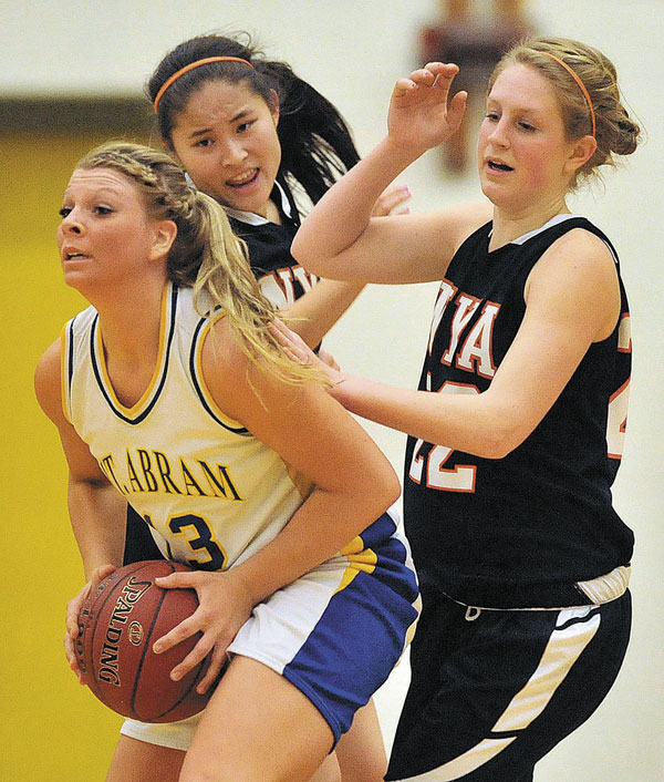 LOOKING FOR OPTIONS: Mt. Abram High School’s Mikayla Luce, left, looks to pass while defended by North Yarmouth Academy’s Lillie Reder, center, and Morgan Scully on Tuesday night in Salem Township. Mt. Abram won 52-35.