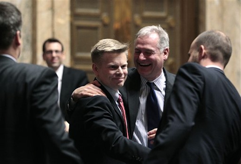 Rep. Jamie Pedersen, D-Seattle, center, is congratulated by Rep. Reuven Carlyle, D-Seattle, right after the House voted to legalize gay marriage in Washington state on Wednesday, Feb. 8, 2012. The action comes a day after a federal appeals court declared California's ban on same-sex marriage unconstitutional, saying it was a violation of the civil rights of gay and lesbian couples. Gregoire is likely to sign the bill next week. (AP Photo/Elaine Thompson)