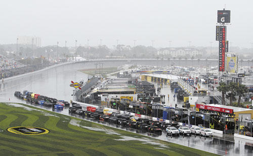 RAINED OUT: Race cars are parked and covered on pit road during a rain delay before the NASCAR Daytona 500 on Sunday in Daytona Beach, Fla. The race was postponed until noon today.
