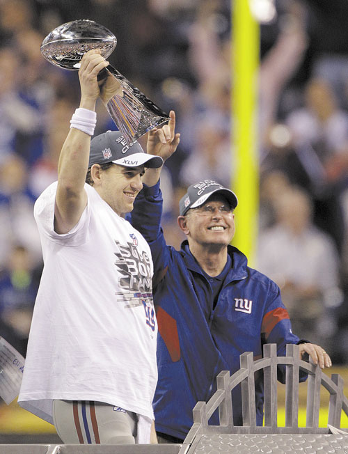 WE DID IT: New York Giants quarterback Eli Manning holds the Vince Lombardi Trophy with head coach Tom Coughlin after beating the New England Patriots in Super Bowl XLVI on Sunday in Indianapolis.