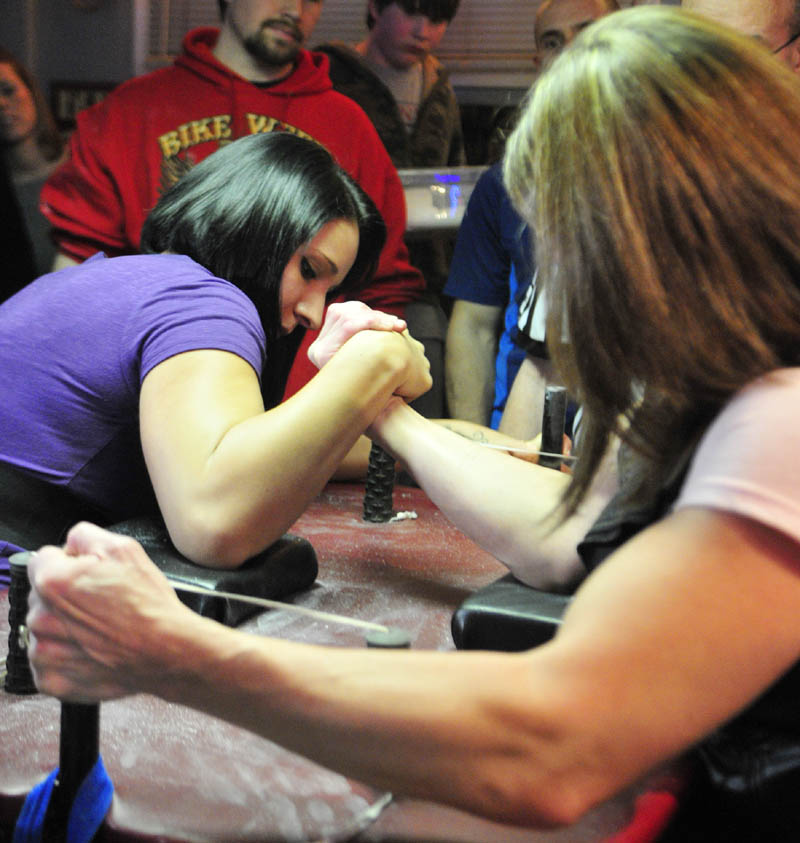 Ashley Mason, left, of Litchfield, beats Debbie Banaian, of Manchester, NH, during the Maine State Arm Wrestling Championships on Saturday night at the Pond Town Tavern in Winthrop.