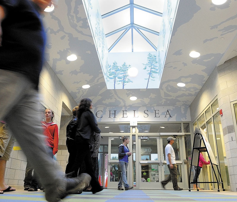 People walk through the lobby during an open house on Thursday night at the new Chelsea Elementary School. The lobby walls and ceiling are painted with trees and patterns inspired by topographical maps.