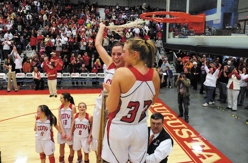 Cony Rams Julie Arbour and Mia Diplock celebrate by cutting down the net after winning the Class A East championship game on Friday night at the Augusta Civic Center.