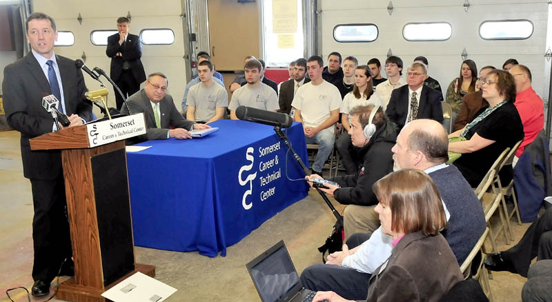 SCHOOL PROPOSAL: Education Commissioner Stephen Bowen, standing, and Gov. Paul LePage, seated at right, address students and educators at Somerset Career & Technical Center in Skowhegan on Wednesday.