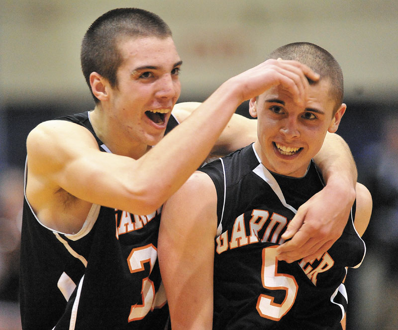 Gardiner High School teammates Aaron Toman, 33, left, and Jake Palmer, 5, right, celebrate as Palmer walks to the foul line for two free throws with seconds left on the semifinals of the Eastern Class B game against Medomak Valley High School at the Bangor Auditorium Wednesday. Gardiner defeated Medomak Valley 57-46.
