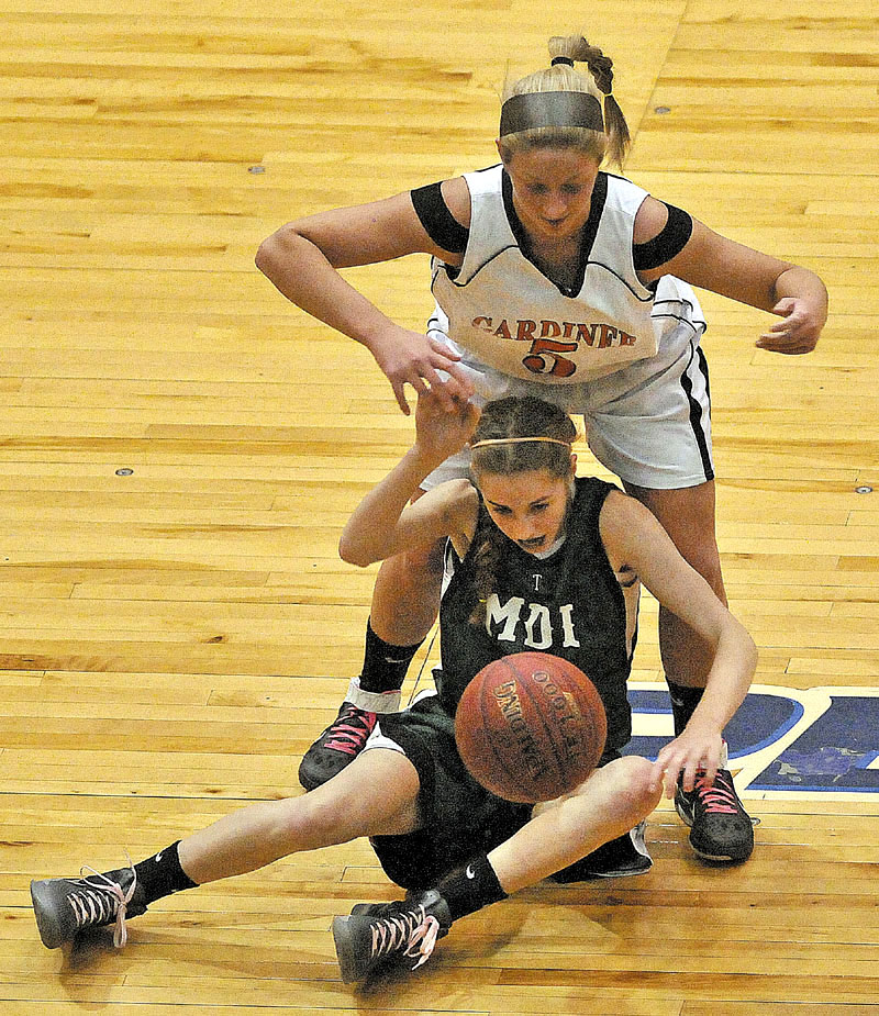 Gardiner High School's Paige Pilsbury, 5, top, fights for the loose ball with Mount Desert Island High School's Sarah Phelps, 5, bottom, in the first half of the Eastern Class B quarterfinals game at the Bangor Auditorium Saturday. Gardiner defeated MDI 63-38.