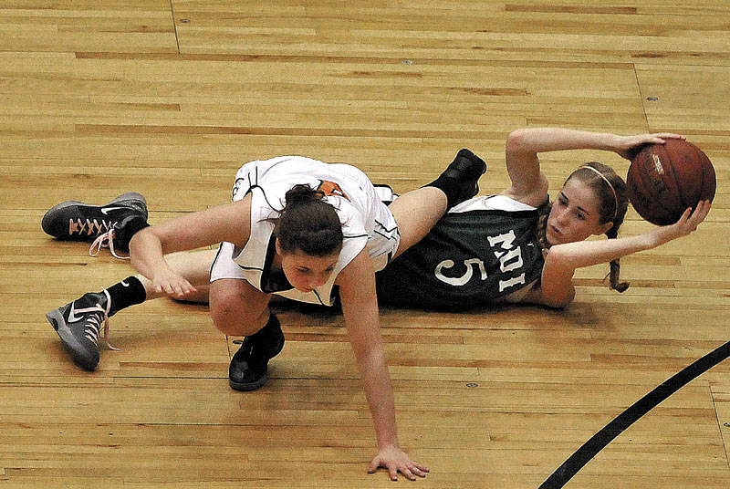 Photo by Michael G. Seamans Gardiner High School's Kylee Granholm, 4, top, tries to avoid Mount Desert Island High School's Sarah Phelps, 5, bottom, after Phelps lost control of the ball in the first half of the Eastern Class B quarterfinals game at the Bangor Auditorium Saturday. Gardiner defeated MDI 63-38.