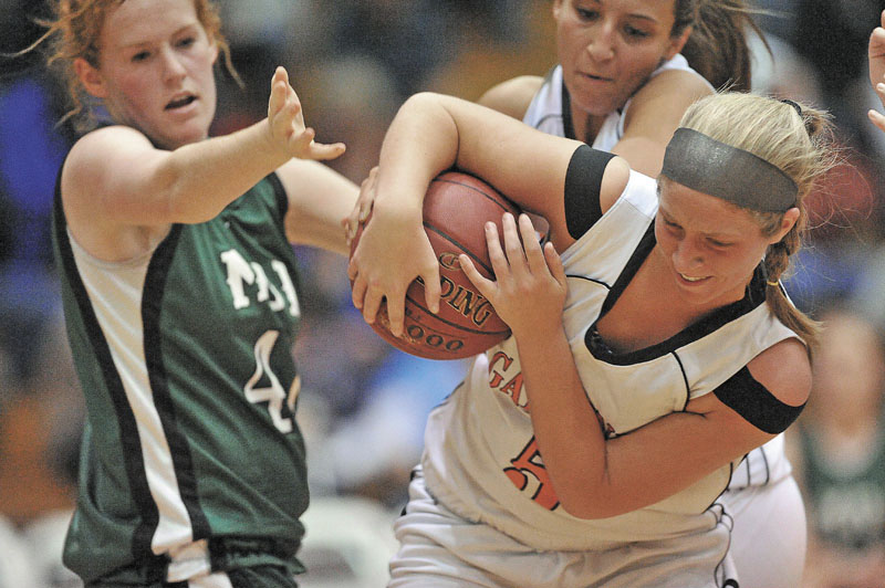 Photo by Michael G. Seamans Gardiner High School's Paige Pilsbury, 5, right, fights for the ball with Mount Desert Island High School's Caroline Mitchell, 41, left, in the second half of the Eastern Class B quarterfinals game at the Bangor Auditorium Saturday. Gardiner defeated MDI 63-38.