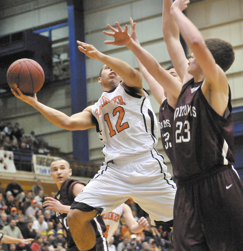 Gardiner High School's Alonzon Connor, 12, drives to the hoop against Nokomis High School defenders Chandler Foss, 32, center, and teammate Andrew Cartwright, 23, right, in the first half of the Eastern Class B quarterfinals game at the Bangor Auditorium Friday. Gardiner won 56-47 in over time.