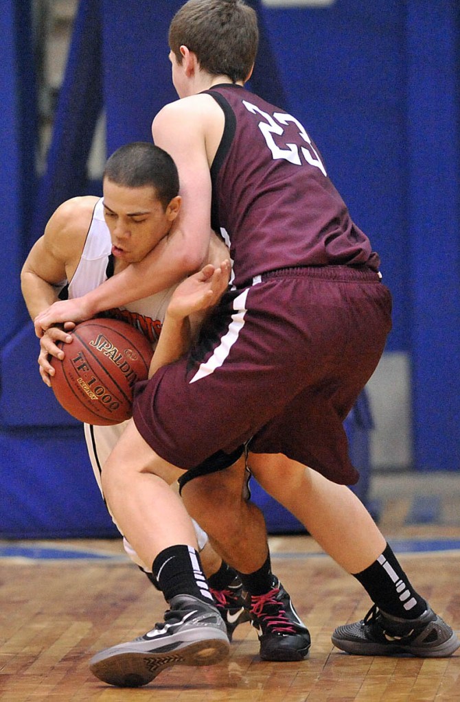 Gardiner High School's Alonzo Connor, 12, facing, and Nokomis High School's Andrew Cartwright, 23, fight for the ball in the first half of the Eastern Class B quarterfinals game at the Bangor Auditorium Friday. Gardiner won 56-47 in over time.