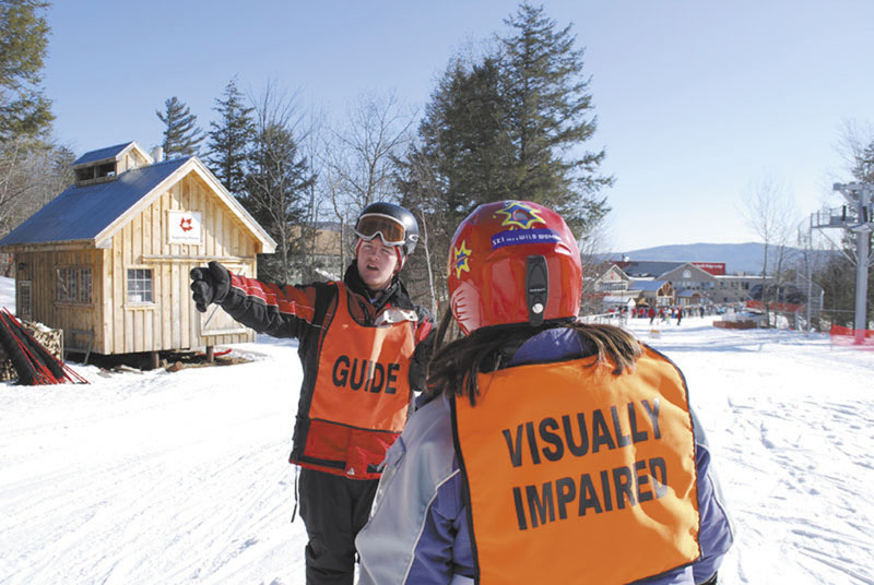 LENDING A HAND: Gould Academy junior Liam Gillis helps instruct a visually impaired skier at Sunday River earlier this month. Gillis helped Gould Academy start up the portion of its ski instructor program that works with Maine Adaptive. Gould’s ski instructor program, “Rugrats,” has been teaching local elementary students to ski for free for 25 years.