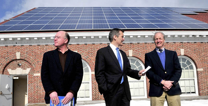 ENERGY FROM ABOVE: Glenn Cummings, center, president and CEO of Good Will-Hinckley/Maine Academy of Natural Sciences, on Monday is flanked by Steve Cole, left, of Coastal Enterprises and Bill Behrens of ReVision Energy under the 110 solar panels that produce energy for the Prescott Memorial Hall building on campus.
