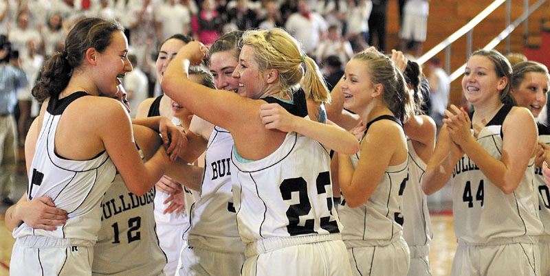 WE DID IT: The Hall-Dale girls basketball team celebrates at midcourt after winning the Western C championship game Saturday night at the Augusta Civic Center. The top-seeded Bulldogs beat No. 7-seeded Waynflete 43-36.
