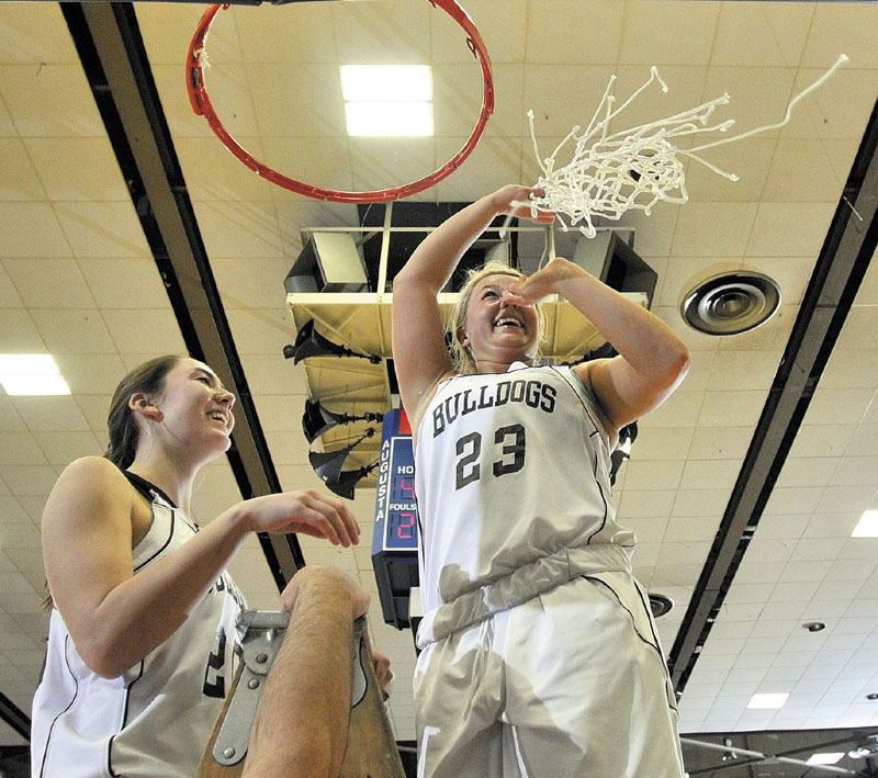 Staff photo by Joe Phelan Hall-Dale seniors Paley Sweet, left, and Carylanne Wolfington celebrate atop the ladder after cutting down the nets following the Bulldogs victory in the Class C West championship game on Saturday night at the Augusta Civic Center.
