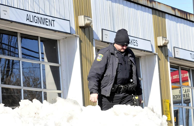ASSAULT SEARCH: Waterville police officer Steve Brame searches the parking lot at Bill's Tire business in Waterville for evidence an assault took place involving Lance DiPietro and another man on Monday.