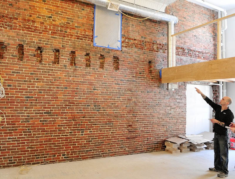Patrick Guerette points at an old door above the notches in the brick wall during a tour of the apartments being built in the old Chernowsky's building in downtown Augusta. He said that the notches used to support beams for a former fourth floor.