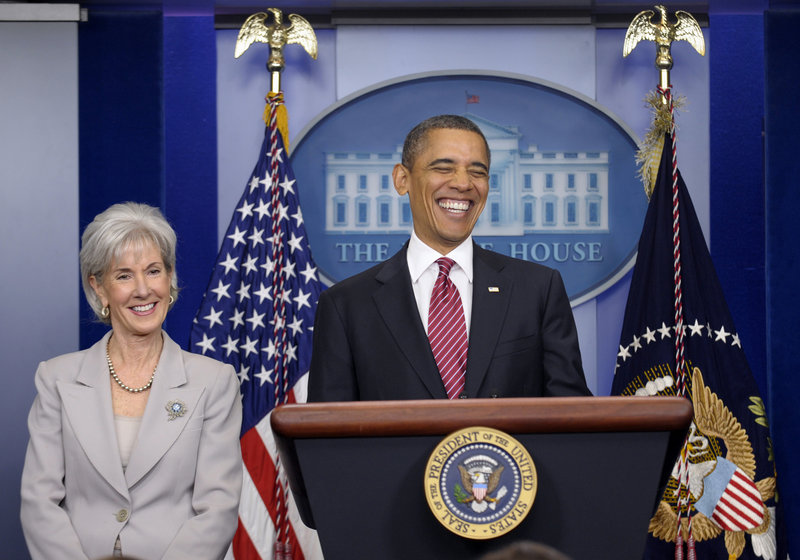 President Barack Obama, standing with Health and Human Services Secretary Kathleen Sebelius, smiles Friday before announcing the revamp of his contraception policy requiring religious institutions to fully pay for birth control. He delivered a statement in the Brady Press Briefing Room of the White House in Washington.