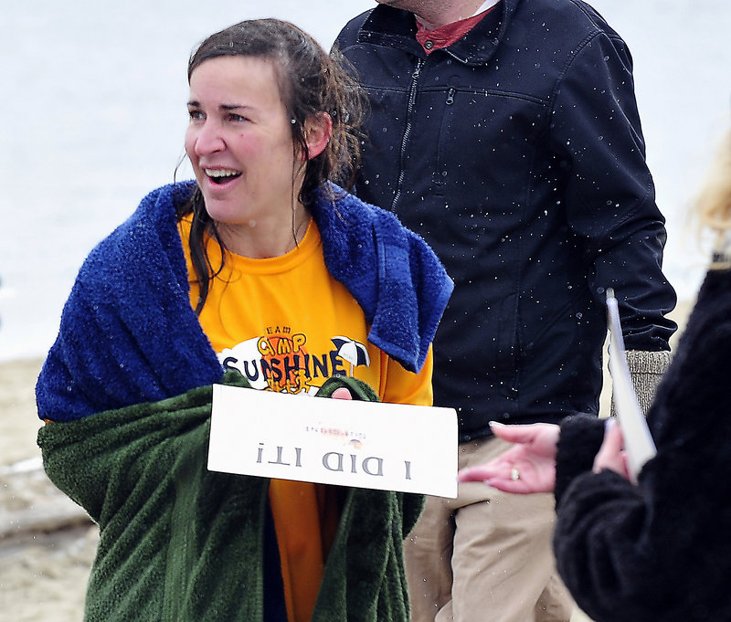 PROOF: The snow was still falling as Cathy Jerome of Boston gets her "I Did It!" certificate after participating in the Camp Sunshine Freezin' for a Reason Polar Dip at East End Beach