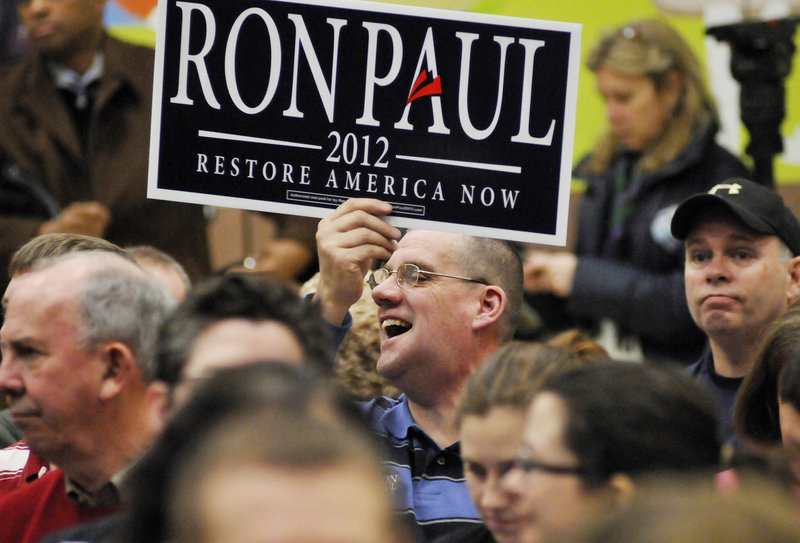 Glenn Strout of Portland holds a sign in support of Texas Rep. Ron Paul before a speech by GOP rival Mitt Romney during the Portland Republican City Committee Caucus on Saturday, Feb. 11.