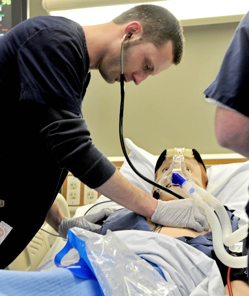 REAL SIMULATION: Student Ric Lewis takes vital signs on a life-like simulated cardiac patient in the TD Simulation lab during the unveiling of the new health-care simulation laboratory at Kennebec Valley Community College on Tuesday.