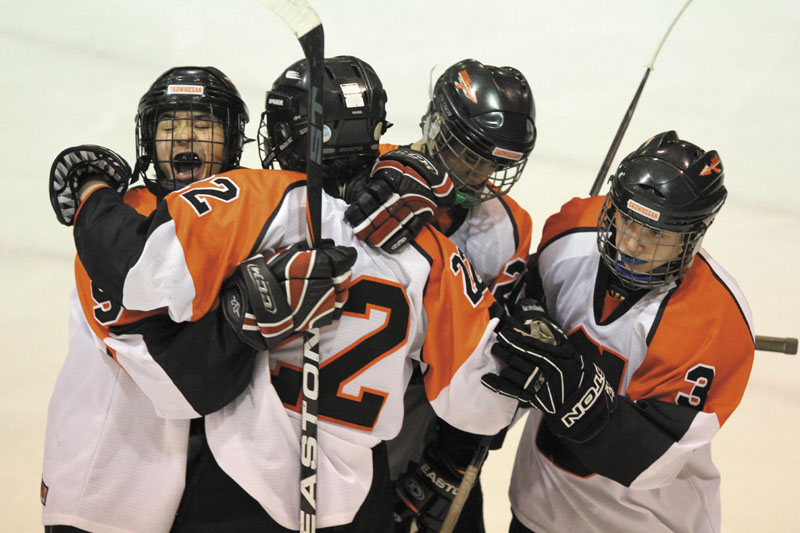 A REASON TO SMILE: After scoring a second period goal, Skowhegan Area High School's Trey Michonski (22) gets a hug from Anthony Paul, left, and several other teammates during Friday night's game against Gray New Gloucester Poland at Sukee Arena in Winslow.