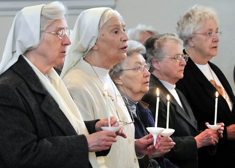 SOLEMN SERVICE: Sisters of the Blessed Sacrament convent lead a candlelit procession during a service on Thursday at St. Francis de Sales in Waterville. The Catholic church will hold a closing Mass on Sunday and will be demolished later this year to make way for an elderly housing complex.