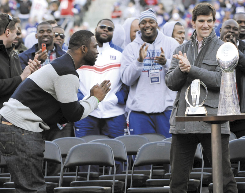 WELL DONE: New York’s Justin Tuck, left, does his signature bow to quarterback Eli Manning, right, as the Giants celebrated their Super Bowl victory Tuesday at MetLife Stadium in East Rutherford, N.J. The Giants defeated the New England Patriots in Super Bowl XLVI on Sunday.