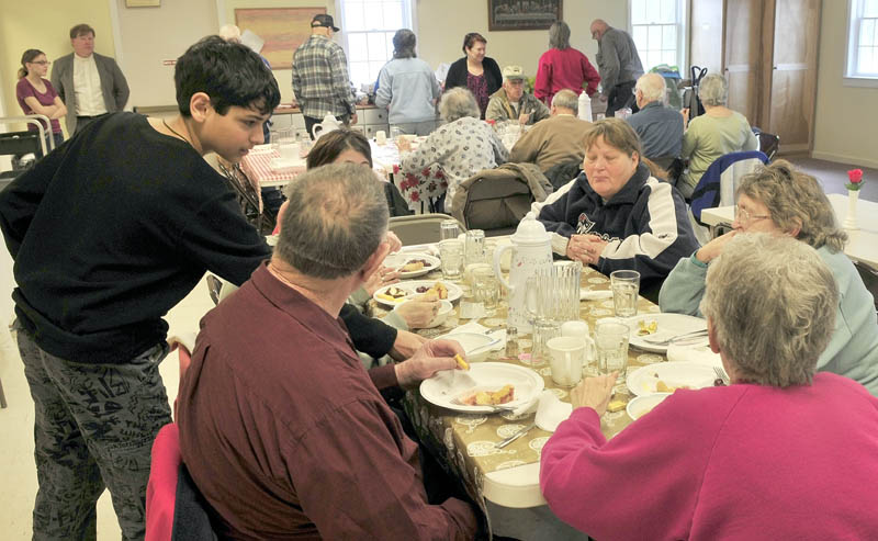 WARMTH: Volunteer Wyatt Howe of Somerset Valley Academy waits on patrons at the Norridgewock Warming Center during lunch at the First Congregational Church on Thursday. In a year the center has grown to 70 people having dinner on Thursdays. At left in back is The Rev. Nathan Richards.