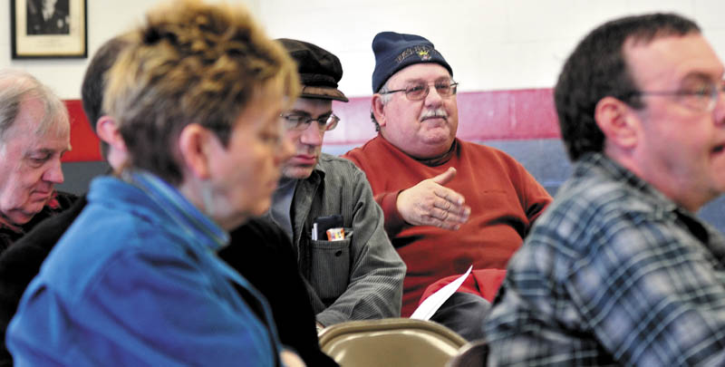 BY THE PEOPLE: Jerry Quirion, center, makes a point Sunday at Winslow's Democratic caucus at the Winslow Fire Department.