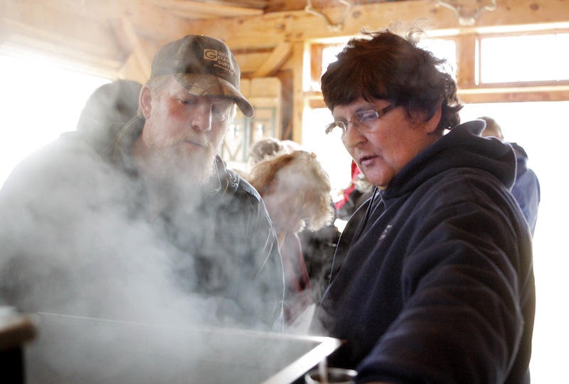 At her sugar house in Gorham, Jo Hartwell explains the sugaring process to Scott Sorenson, also of Gorham, during Maine Maple Sunday on Sunday, March 25, 2012. Sugar houses throughout Maine opened their doors to visitors on Sunday.